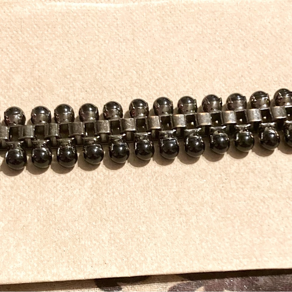 Edgy, yet elegant. This bracelet features metal links and black drop beads